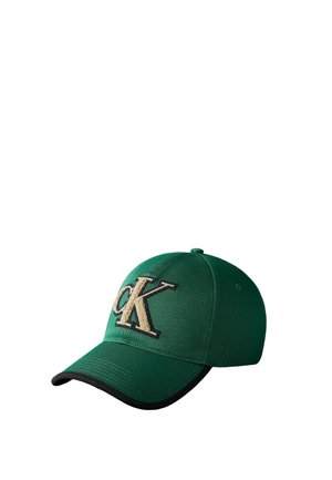 Gorra de béisbol verde con borde negro en la visera y gran logo texturizado "CK" en beige y negro en el panel frontal.