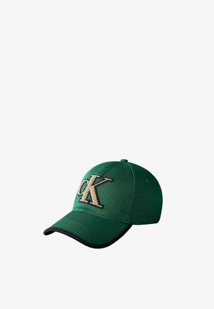 Casquette de baseball verte avec bord noir sur la visière et grand logo texturé "CK" beige et noir sur le panneau avant.