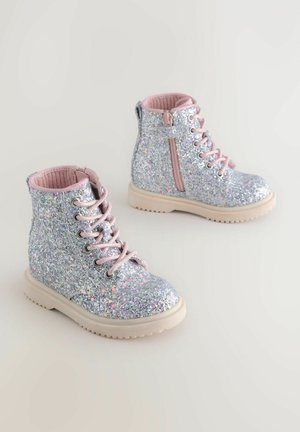 Bottines scintillantes argentées avec des accents roses, bout rond, laçage à l'avant et fermeture éclair sur le c�ôté. Surface texturée avec une semelle en caoutchouc épaisse.