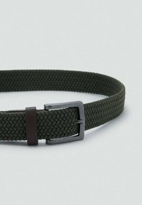 Kestävä vihreä kudottu vyö, jossa on tekstuuripinta, tumma metallivaihtoehto ja ruskea nahkakiinnityslenkki säädettävyyttä varten.