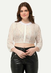 Top corto in pizzo bianco con maniche a tre quarti, dettaglio plissettato sul davanti e scollatura a scallop. Abbinato a pantaloni in pelle neri con cerniere.