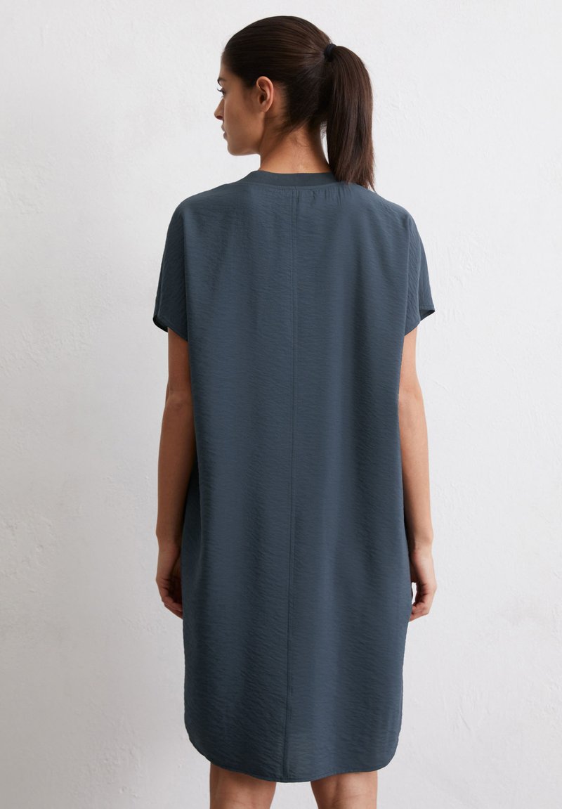 Robe à manches courtes, longueur genou en gris foncé, fabriquée à partir d'un tissu texturé. Elle présente une silhouette droite et un détail de couture au dos.