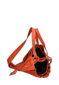Oranje leren handtas met een slouchy ontwerp, een strakke bovenkant en een enkele schouderriem. Het interieur heeft een zwarte voering.