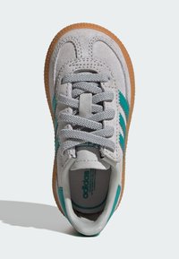 Baskets en suede gris avec des rayures turquoise, lacets gris texturés et semelle en caoutchouc gomme. Comprend un col rembourré et un marquage intérieur.