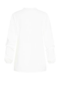 Camicia bianca a maniche lunghe con scollatura rotonda e polsini arricciati, caratterizzata da una texture liscia e una vestibilità rilassata. Nessun motivo o dettaglio visibile.