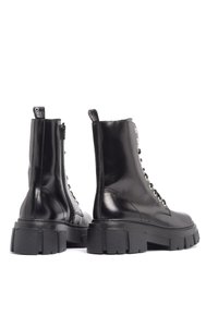 Svarta läderankelboots med kraftig sula, snörning fram, sidodragkedja och dragögla. Slät yta med kontrasterande hårdvaruaccenter.