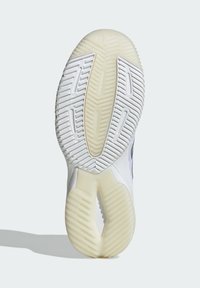 Sålen på en sneakers med hvid gummi, tekstureret mønster, rillede skridmdesign og semi-gennemsigtige accenter.