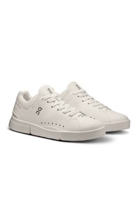 Scarpe sportive bianche con tomaia in pelle sintetica liscia, fodera in tessuto, design perforato per traspirabilità e suola imbottita.