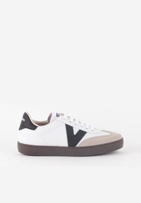 Vita sneakers i vitt med en suédebeige tåhätta, svarta accenter och en framträdande svart "V"-logotyp. Har en texturerad vit ovandel och brun sula.