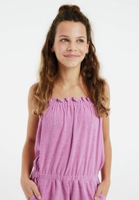 Roze mouwloze jumpsuit met een elastische halslijn en tailleband, gemaakt van een zachte, gestructureerde stof en met zijzakken.