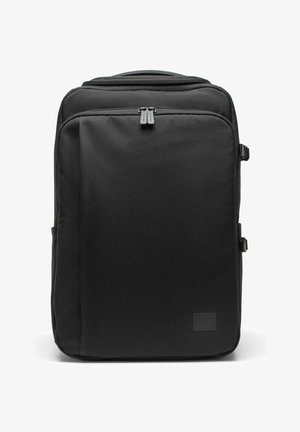 Sac à dos rectangulaire noir avec une poche avant zippée, des doubles curseurs de fermeture éclair, des sangles latérales à boucle et une poignée de transport sur le dessus.