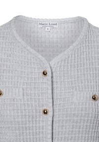 Hellgraue Strickjacke mit strukturiertem Muster, ausgestattet mit goldfarbenen Knöpfen und zwei Brusttaschen. Das Etikett trägt die Aufschrift "Marie Lund, Kopenhagen, S."