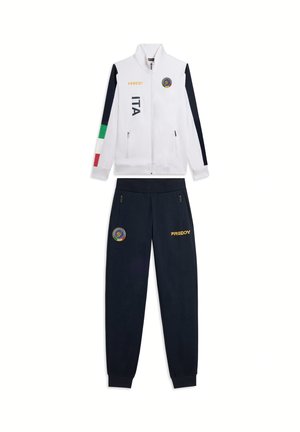 Giacca bianca con zip e colori della bandiera italiana sulla manica, "ITA" e loghi; pantaloni blu navy con loghi abbinati e tasche laterali con zip.