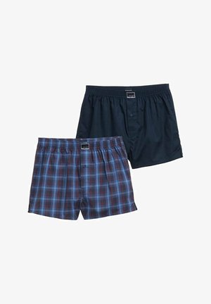 Dva pánská boxerky, jeden jednobarevný tmavě modrý, druhý modro-červená kostka, oba s elastickým pasem a předními knoflíky.