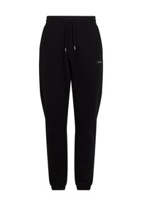 Schwarze Jogginghose aus weichem Material. Elastischer Bund mit Kordelzug, schmal zulaufende Bündchen und ein kleines Markenlogo an der Seite.