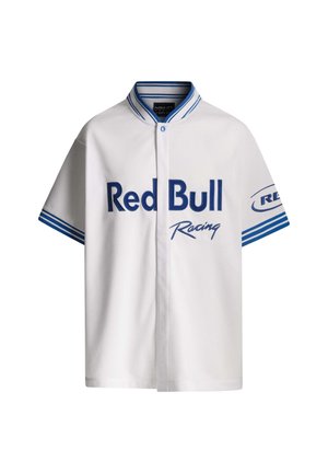 Vit kortärmad skjorta med blå detaljer, med "Red Bull Racing" i fet blå text och knappstängning. Slät textur och avslappnad passform.