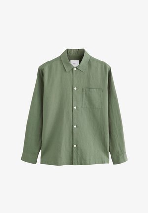 Roheline pika varrukaga särk, mis on valmistatud tekstuurse kangaga, varustatud kraega, mis kinnitub nööpidega, esitasku ja valgete nööpidega.