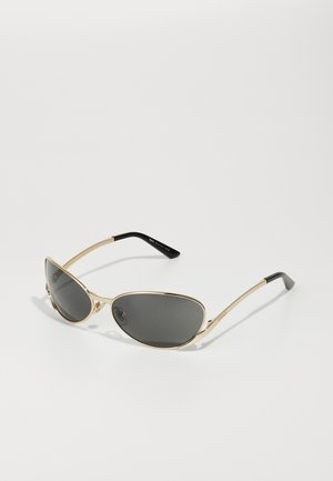Sonnenbrille mit einem goldenen Metallrahmen, ovalen dunkelgrauen Gläsern und schlanken Bügeln mit schwarzen Enden. Dezente Markenkennzeichnung an der Seite.