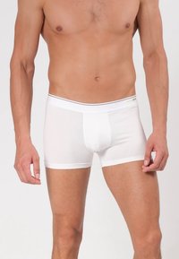 Weiße Boxershorts aus glattem Stoff mit figurbetontem Schnitt. Sie verfügen über einen weichen Bund mit dünnen grauen Akzenten und eine konturierte Tasche.