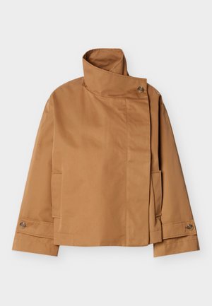 Hellbraune Jacke mit hohem Kragen und asymmetrischem Knopfverschluss, langen Ärmeln, Seitentaschen und geknöpften Manschetten, flach auf weißem Hintergrund ausgelegt.