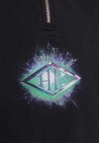 Černá mikina na zip s velkým grafickým vzorem v podobě diamantového tvaru v purpurové a zelené barvě, uprostřed s nápisem 'HK' a efekty rozpršení.