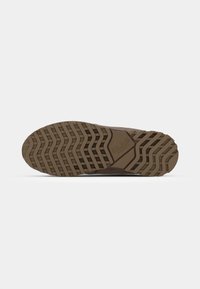 Brown sneaker sole with a zigzag tread pattern. Rubber material. Features a hexagonal accent and brand logo in the midsole.