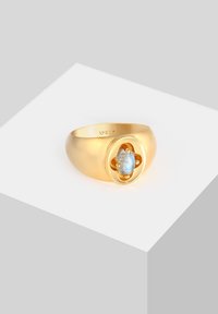 Gold ring with a smooth band and a central oval labradorite stone set in a flower-shaped bezel, featuring small dot accents.