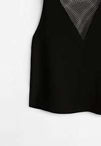 Haut sans manches noir avec un décolleté en V et un panneau en mesh. Texture de tissu lisse avec une ourlet arrondie.