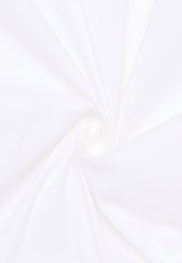 White fabric with a smooth texture, arranged in a spiral pattern, showcasing its lightweight and flexible qualities.