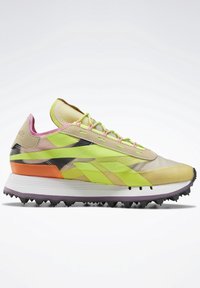 Chaussure de course légère avec une tige en mesh beige agrémentée d'accents verts et oranges vibrants, une semelle texturée et plusieurs couches de couleurs.