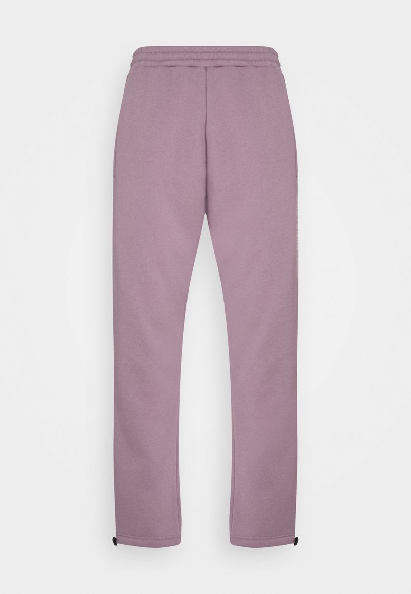 Lila Jogginghose mit Kordelzugbund, schmal zulaufenden Beinen, seitlichen Taschen und elastischen Bündchen. Weicher, strukturierter Stoff. Minimalistisches Design.