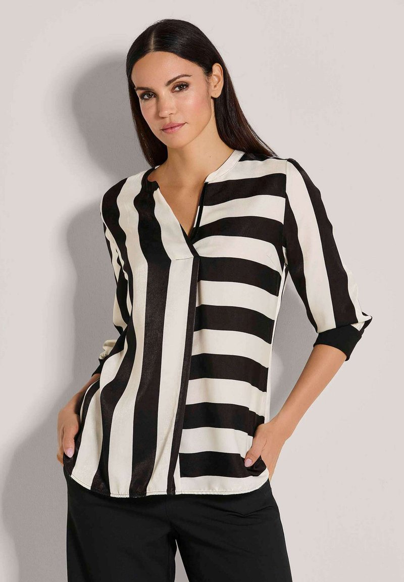 Zwart-witte gestreepte blouse met een V-hals, driekwart mouwen en een relaxte pasvorm. Zacht materiaal met een strakke afwerking.