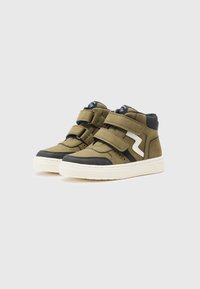 Sneakers typu mid-top w oliwkowym materiale z czarnymi akcentami, z dwoma paskami na rzepy i białym, zygzakowatym detalem z boku.