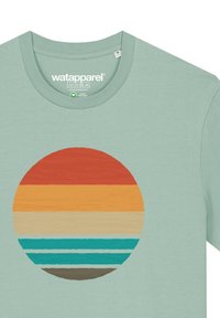 T-shirt en coton vert menthe avec un graphique circulaire de bandes horizontales empilées en orange, jaune, crème, turquoise et marron.