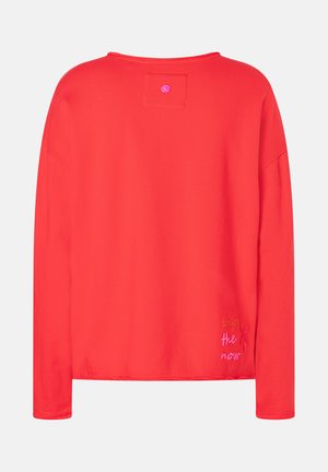 Helles rotes Langarmshirt mit einem kleinen Patch und einem Knopf in der Nähe des Kragens, und "genieße den Augenblick" in buntem Faden in der Nähe des Saums gestickt.