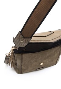 Borsa a tracolla in faux leather verde oliva con una tracolla texturizzata, tasca con zip e dettaglio in frange. Presenta cuciture a contrasto e accenti in metallo.
