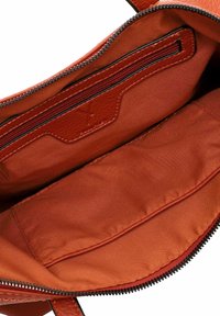 Ruskea nahkalaukku, jonka sisällä on vetoketjullinen tasku ja sileä kangasvuori. Sisältää teksturoitua korostusta ja kontrastivärisen vetoketjun.