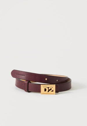 Ceinture en cuir marron foncé enroulée avec une boucle rectangulaire en or gravée de "D2" sur un fond uni.