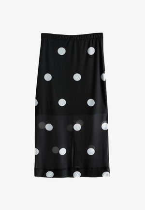 Sorte nederdel med store hvide prikker. Lavet af letvægtsstof med elastisk talje. Længden når midt på læggen.