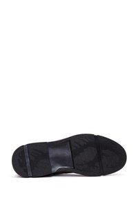 Suela de zapato negra con un patrón de banda de rodadura de goma texturizada, acento de mediopie suave y forma contorneada. Talla 42 marcada en la suela.