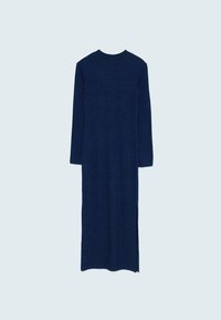 Longue robe en maille côtelée bleu marine avec manches longues, col rond et fente latérale sur fond clair.