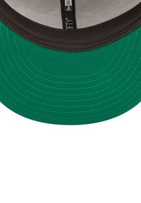 Gorra de béisbol verde con visera negra. Presenta costuras gruesas y un borde texturizado. El interior tiene un forro de malla con una etiqueta de marca.