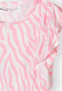 Chemise en coton rose avec un motif rayé zèbre blanc, encolure ronde et pressions aux épaules, ornée de volants aux manches.