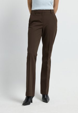 Bruine op maat gemaakte broek met een slim fit, voorzien van een soepele textuur, tailleband, zijzakken en een plooi aan de voorkant. Gecombineerd met zwarte hakken.