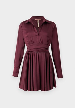 Vestito camicia color malva in tessuto morbido con scollo a V, maniche lunghe, vita aderente e gonna svasata. Presenta un colletto con bottoni.