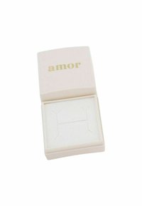 Caja de joyería rosa con el texto dorado "amor" en la tapa, que cuenta con un cojín interior blanco con cortes para exhibir las joyas.