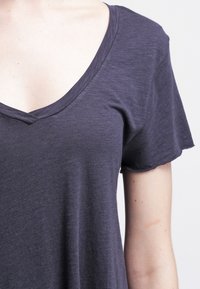 Tmavě šedé tričko s výstřihem do V vyrobené z měkké, lehké tkaniny, s krátkými rukávy a volným střihem, s jemnou texturou a bez vzorů.