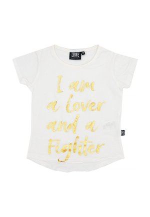 T-shirt blanc à manches courtes avec une inscription dorée : « Je suis un amoureux et un combattant. »