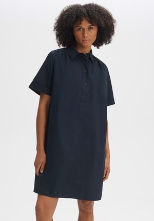 Schwarzes Kurzarmhemdkleid aus leichtem Material mit durchgehender Knopfleiste, Kragen und lockerer Passform, versehen mit seitlichen Taschen.