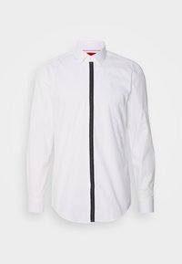 Chemise blanche à manches longues boutonnée avec un col classique présentant une bande noire verticale au centre devant.